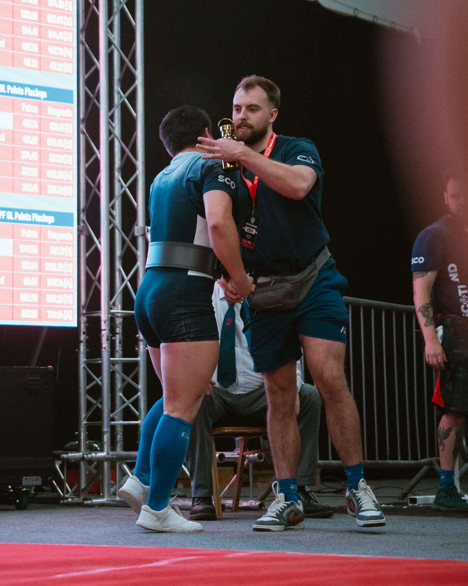 Apto Performance coach congratulating a lifter on the platform